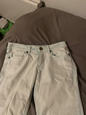 Vita jeans från Replay - Säljer ett par vita jeans från Replay med klassisk femficksmodell. Gillar man inte skinny jeans, är dom perfekta för folk som gillar att sy om. Jeansen har metallknappar och detaljer samt en liten logga på bakfickan. Tillverkade i mjuk denim som är sköna att bära hela dagen.