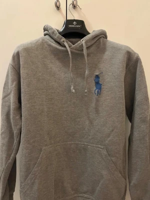 Grå Ralph lauren hoodie med stor logga - Säljer min Ralph lauren hoodie! En grå Ralph lauren hoodie med stor logga samt en 3:a på både rygg och höger arm. Går knappt att få tag på i vuxenstorlek längre och kostar mellan 2000-3000 ny (osäker på exakt pris då den är köpt här på Plick). Storlek S och inga vidare defekter. Möjligtvis att den kan vara lite sleten på ändarna av snörena (hör av er för bild), men verkligen inget man märker eller så. Hör av er vid frågor! Mvh Kåre. 