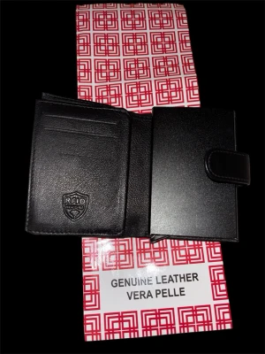 Svart plånbok i äkta läder RFID - Stilren svart plånbok från Vera Pelle i äkta läder med RFID-skydd. Plånboken har flera kortfack och ett praktiskt knäppe för extra säkerhet. Perfekt för dig som vill ha både funktion och snygg design i vardagen.