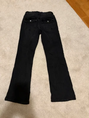 Svarta bootcut jeans med fickor! - Svarta fina jeans från Kappahl, dom är i strl 164! Dom är i väldigt gott skick har använt de 2 - 3 gånger!❣️