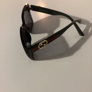 Svarta solglasögon  - Svarta solglasögon med kantig form och mörka linser. 