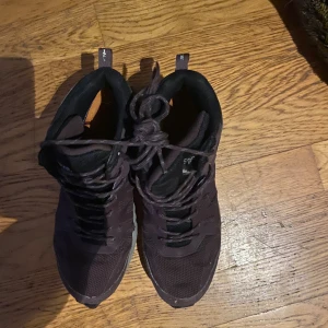 Lila sneakers från Sprayway strl 40 - Säljer ett par mörklila sneakers från Sprayway i storlek 40. Skorna har snörning och är tillverkade i syntetmaterial med mesh för bra andningsförmåga. Perfekta för vardagsbruk eller promenader.