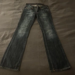 Blå bootcut lowwaist jeans från Narli  - Snygga blå lågmidjade jeans från Narli med bootcut passform och coola slitningar. Bakfickorna har orangea stenar i ett jättefint mönster. Jag skulle säga att de är små i storleken då jag vanligtvis har 25/26 i waist men de är försmå. De är också lite för långa för mig som är 168 cm. Ordiarie pris ca 2000 kr och är endast testade!