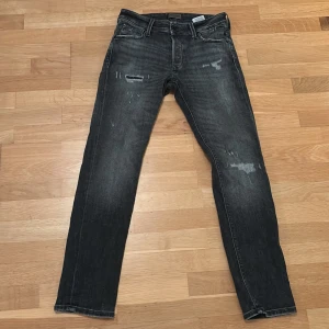Jack and Jones jeans  - Grå/svarta Jack and Jones jeans. Storlek: 29/30. Skick 10/10 endast använts vid fåtal tillfällen. Skriv om ni har några funderingar!