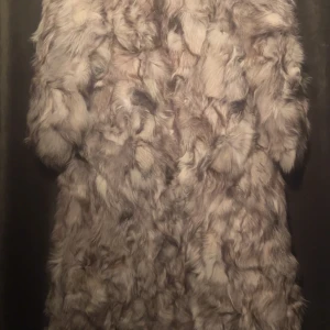 Exklusiv vintage silverrävspäls från 70-talet - Exklusiv vintage silverrävspäls från 70-talet – sällsynt fynd  Ett unikt samlarplagg för den som uppskattar klassisk lyx och tidlös stil. Äkta silverräv, handgjord på 1970-talet med vacker naturlig glans och fyllig textur. Bevarad i utmärkt skick med originalfoder och elegant snitt som framhäver silhuetten.  🌿 Äkta vintage – unik och svår att hitta ✨ Mycket välbevarad, endast varsamt använd 👗 Passar både som statement-piece och samlarobjekt  Storlek: S/M Skick: Utmärkt vintage 