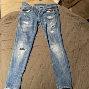 Blå skinny jeans från George, stl 30 - Snygga blå skinny jeans från George i storlek 28. Jeansen har slitna detaljer och hål på benen för en cool, trendig look. Klassisk femficksmodell med knappgylf och ljus tvätt. Perfekt passform med smal siluett och bekvämt jeansmaterial. Dem passar även storlek 29 och 28. Ny pris 3200kr