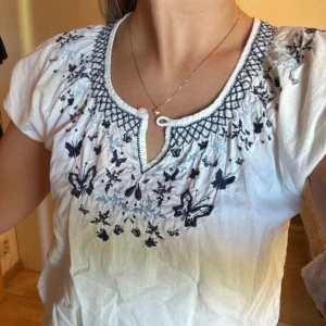 vit blus med blått broderi - Jättesöt vit blus med fina detaljer! 