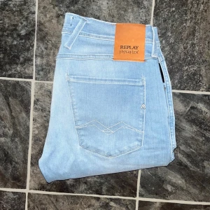 Replay Anbass hyperflex jeans - Snygga ljusblå Replay Hyperflex Anbass jeans med klassisk femficksdesign och diskret logga på bakfickan. Stretchigt material för extra komfort och smal passform. Midja 37cm, längd 103cm. JAG SKICKAR EJ FLER BILDER NÄR JAG BÄR JEANSEN! för storleksguide hänvisar jag till måtten och för bättre inblick i passformen rekommenderar jag att googla på modellnamnet. Jeansen kan vara uppsydda utan att jag noterat det så kolla måtten noggrant :) s4