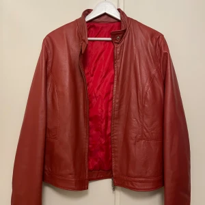 Vintage läderjacka - Vintage röd läderjacka i superbra skick. Storlek M för tjej som är 175cm lång, true to size