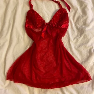 Rött nattlinne - Ett rött nattlinne i spets/ mesh me prickar och ett band i satin som man knyter i nacken, därav öppen i ryggen. Köpt second hand men aldrig använt av mig, står varken storlek elelr märke men skulle gissa på S? Vaddering i kuporna men ingen push! Skriv om du funderar över något💋