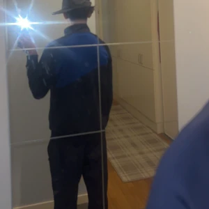 Nike blå och svart hoodie med dragkedja - Säljer en snygg hoodie från Nike i svart och blått med vit logga på bröstet. Tröjan har dragkedja framtill, hög krage och långa ärmar. Perfekt för dig som gillar sportig stil och vill ha något bekvämt och stilrent.