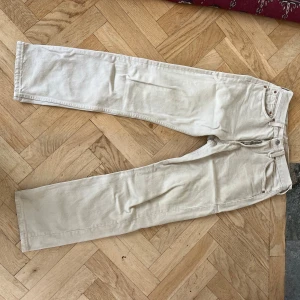 Levi's 501 beige jeans W31 L30 - Säljer ett par klassiska Levi's 501 jeans i beige färg. Modellen har rak passform, fem fickor och knappgylf. Materialet är 100% bomull vilket ger en skön och autentisk jeanskänsla. Perfekt för dig som gillar tidlös stil och vill ha ett par jeans som funkar till allt.