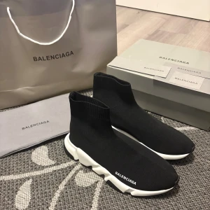 Balenciaga Speed Trainer svarta sneakers - Svarta Balenciaga Speed Trainer sneakers med vit chunky sula och stickad ovandel i stretchig textil. Strömlinjeformad siluett med Balenciaga-logga på sidan och bak på sulan. Superlätta och bekväma, perfekta för en clean och modern look.