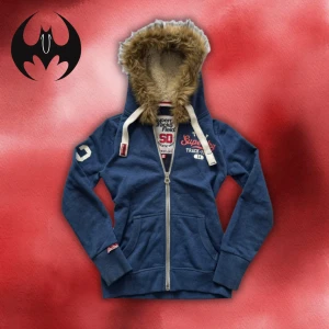 Blå dragkedja hoodie med fodrad pälshuva från Superdry XS/S - Blå dragkedja hoodie med fodrad pälshuva med vit markerade ’72’ och superdry logo | size XS/S | Längd: 62cm Armlängd: 56cm Axelbredd: 45cm | Passar för 158-165 cm