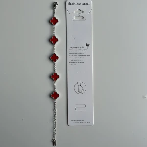 Red/light-silver alhambra bracelet  - Snyggt armband med fem röda fyrklöver-formade berlocker på en tunn silverfärgad kedja. Tillverkat i rostfritt stål, med detaljerade kanter runt varje berlock. Perfekt för dig som vill ha en färgklick på handleden och gillar unika former.