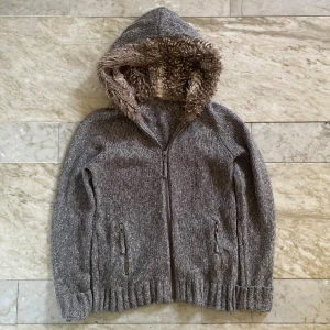 Cardigan med päls  - Skön stickad cardigan/kofta med päls! Passar perfekt nu till hösten och vintern! Hittar ingen lapp men den sitter som en S! Mått: längd- 60cm, Bredd- 40cm! Hör av dig vid ytterligare frågor! Mvh 