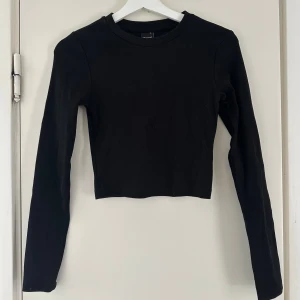Svart långärmad topp Gina Tricot - En svart långärmad topp från Gina Tricot. Enkel och stilren design med rund halsringning. Något kortare i modellen och i toppskick! 