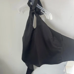 Top från Gina - Top från Gina i satin tyg som man knyter både vid nacken och ryggen. Skriv vid fler.