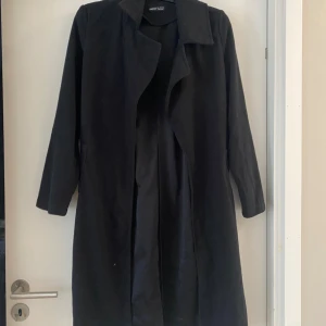 Svart kappa från SHEIN, storlek S - Stilren svart kappa från SHEIN i storlek S. Jackan har en klassisk krage, lång ärm och rak passform. Materialet känns mjukt och har en lätt borstad yta. Perfekt för dig som vill ha en enkel och snygg look. Har aldrig använt.  
