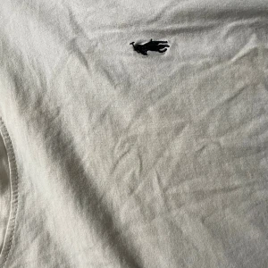 Vit t-shirt från Ralph Lauren - Vit t-shirt från Ralph Lauren med klassisk svart broderad polospelare på bröstet. Rund halsringning och mjukt bomullsmaterial som känns skönt mot huden. Enkel och stilren design som funkar till allt. Perfekt för dig som gillar ikoniska märken. Storlek m/L