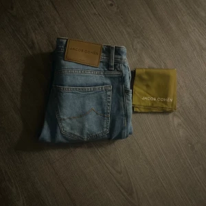 Ljusblå jeans från Jacob Cohën - Jacob Cohën i modellen Bard. En av de nyare modellerna så finns fåtal som säljer dessa. Följer med en ”Scarf” som är med på bild 1. Använt sparsamt och inga stora täcken på bruk. Kom med byten och bud.