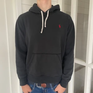 Ralph lauren hoodie - Säljer denna riktigt snygga svarta hoodien från Ralph lauren! Den är i bra skick enda defekten är att tyget är lite sprucket längst ut på ärmarna (skriv för bild) , Storlek M jag på bilderna är 184 cm och väger 81 kg den är lite för kort för mig så passar bäst på den som är 170-180 cm, hör gärna av dig vid frågor!