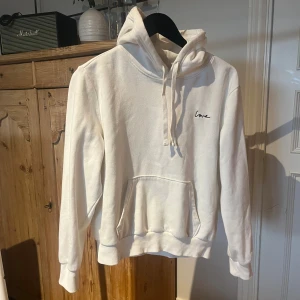 Vit hoodie  - Vit hoodie med broderad svart text 'love' på bröstet. 