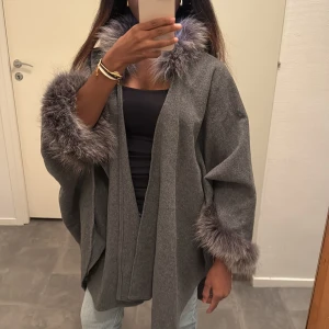 Kappa med fuskpäls - Snygg oversized kappa/poncho med breda ärmar och fluffiga fuskpälsdetaljer vid krage och ärmslut 🧚🏾‍♀️