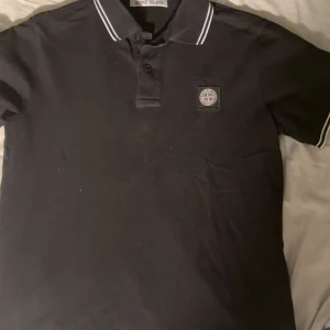 Svart pikétröja Stone Island S - Pikétröja feån Stone Island, köpt i El Corte Inglés i marbella puerto banus, Äkta! Passar inte mig längre så någon annan får njuta av denna vackra tröjan :)