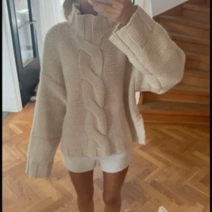 Beige stickad tröja från Zara - Supermysig beige stickad tröja från Zara med grov flätstickning framtill och hög krage. 