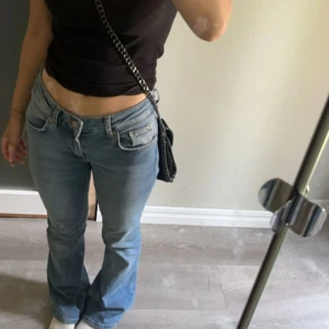 Blå bootcut jeans med låg midja - Säljer ett par ljusblå jeans med bootcut-modell och låg midja, modellen low boot från Lager 157 i storlek xs short length. 