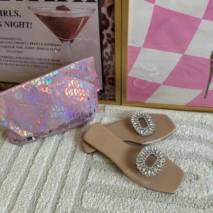 Beige sandaler med strassdetaljer helt nya! - Snygga beige sandaler med fyrkantig tå och transparent rem dekorerad med glittrande strass. Perfekta för att lyfta din outfit med en touch av glamour. Låg klack och platt sula för bekväm känsla.