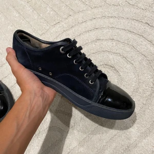 Lanvin cap toe - Säljer ett par helsvarta lanvins uk7 i använt skick. Både sulan och mockan har tecken på användning men är i övrigt i bra skick. Det ända tråkiga med skorna är att sömnen vid sulan har börjat släppa lite på högra skorn, men det går nog lätt att fixa om man vet hur man gör. Inget OG medföljer Hör av er vid minsta funderingar!