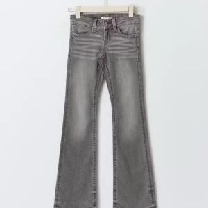 Grå bootcut jeans med slitningar - Snygga grå jeans med bootcut-modell och lätt slitna detaljer framtill. Klassisk femficksdesign, bälteshällor och dragkedjegylf. Perfekta för dig som gillar en retrovibe och vill ha ett par jeans som sticker ut. Säljer då de inte använts på länge❤️Fråga gärna om bilder