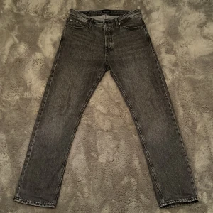 Grå jeans i rak modell - Ett par schyssta mörkgråa jeans med rak/relaxed passform. Storlek W31 L32. 