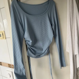 Ljusblå ribbad topp med snörning - Säljer en ljusblå långärmad topp från Shein, knappt använd 💙