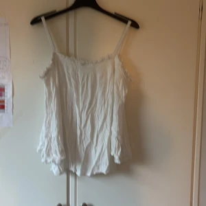 Vit blus med volangärm  - Supersöt vit blus med utsvängda korta ärmar. Men lite spet detaljer. 