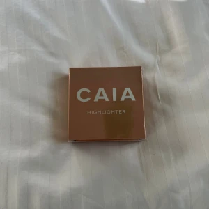 CAIA Highlighter  - Säljer en CAIA highlighter i färgen Cannes. Kommer i en snygg, guldig kompakt dosa med spegel. Ger en glowig, champagneguldig finish och har en silkeslen formula som smälter in i huden. Perfekt för att framhäva kindben, näsrygg och amorbåge.