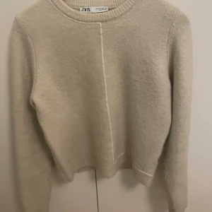Beige stickad tröja från Zara -  Beige trendig stickad tröja från Zara med lång ärm och rund hals. Storleken är M men skulle säga att den funkar lika bra som S. Endast använd några få gånger så inga synliga slitage!💕