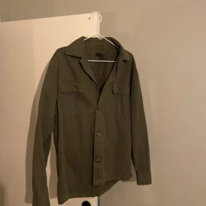 Overshirt - Tja, säljer nu denna väldigt snygga overshirten i en olivgrön färg. Storlek S väldigt fint skick utan några defekter alls. Skriv vid minsta lilla fundering! Pris är ej hugget i stenen.