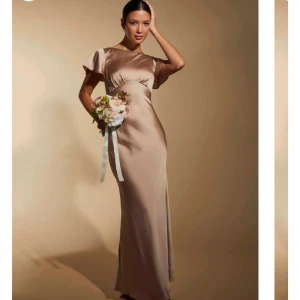 Champagne Satin balklänning  - Som man ser i bilden är den mer champagne färgad i verkligheten. Använd endast en gång på balen. Säljer clutchen till med i en annan annons. Finns lite revor men syns inte alls i verkligenheten. Sista bilden visar ett blå streck som var ritad den syddes men det går enkelt bort när man chemtvättar. Skriv för mått och andra frågor💗