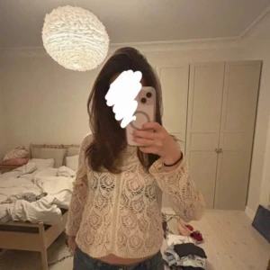 Beige spetsblus från Odd Molly - Superfin beige spetsblus från Odd Molly med lång ärm och vackert broderat mönster. Blusen har en lätt croppad passform och är genombruten med snygga detaljer längs kanterna. Perfekt för dig som gillar romantisk och bohemisk stil.