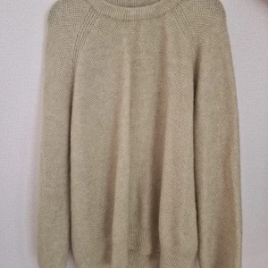 Ljus grön stickad tröja med rund hals - En stilren ljus grön stickad tröja med rund halsringning och långa ärmar. Tröjan har en klassisk passform och är perfekt för lager-på-lager under kyliga dagar. Enkel och tidlös design som passar till det mesta.