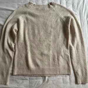 Beige stickad tröja från Vero Moda - Mysig beige stickad tröja från Vero Moda i storlek S. Tröjan har rund halsringning, ribbade muddar och en enkel, klassisk design som är lätt att matcha. Perfekt för lager-på-lager under kyliga dagar. Använt en gång.