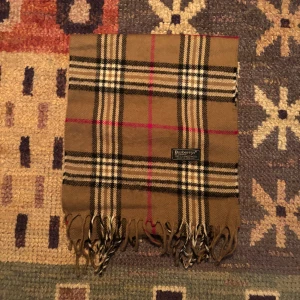 Vintage Burberry Halsduk scarf  - -Riktigt bra skick. Nypris på dessa ligger på runt 5000kr, vilket gör detta till ett sjukt bra pris! Halsduken är gjord i Lamull, och är perfekt inför hösten och den kommande vintern. Anledningen till att det står ”Burberry’s” och inte ”Burberry” på lappen är eftersom halsduken är från några år tillbaka, innan de bytte namn! Om du har någon fråga är det bara att skriva till mig. /elgnce (5)