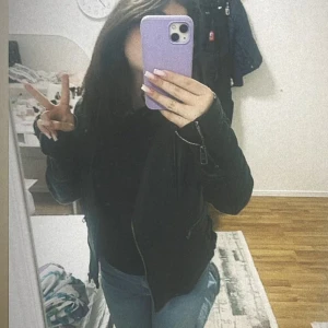 Svart skinnjacka med dragkedja - Säljer en svart skinnjacka med snygga dragkedjor och klassisk bikerstil. Jackan har lång ärm och sitter riktigt schysst på kroppen, perfekt för dig som vill ha en cool och tidlös look. Passar till jeans och t-shirt för en enkel streetstyle.