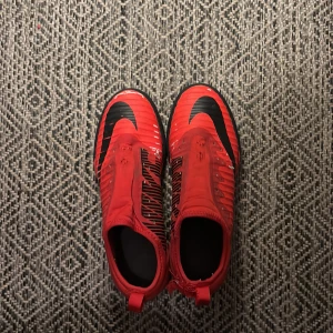 Röda Nike fotbollsskor med svart sula - Säljer ett par röda Nike fotbollsskor med svart sula, anledning att jag säljer är att de är för små. 