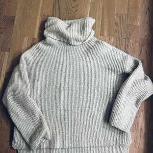 Beige polotröja från Vero Moda - Säljer en beige, ribbstickad polotröja från Vero Moda i storlek XS. Tröjan har en hög och bred polokrage, långärmad design och är tillverkad i mjukt stickat material. Perfekt för att hålla sig varm och snygg under kyliga dagar.