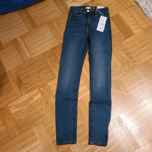 Molly highwaist skinny jeans blå XS - Mörkblå Molly highwaist jeans från Gina Tricot i storlek XS. Superslimmad passform med hög midja och klassiska fem fickor. Jeansen har snygga kontrastsömmar och är tillverkade i stretchig bomullsblandning för en bekväm känsla.