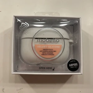 Mobello Velvet Silicone Case för AirPods Pro 1/2 - Mobello Velvet Silicone Case i vitt, passar AirPods Pro 1/2. Mjukt silikon med anti-rep microfiber, metallkarbinhake och stöd för trådlös laddning. Produkten är ny i förpackning, inga synliga defekter.